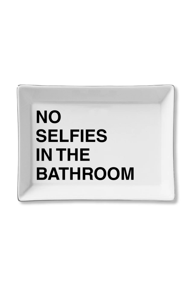 A rectangular white ceramic tray with rounded corners and bold black text that reads 'NO SELFIES IN THE BATHROOM' on a clean white background.