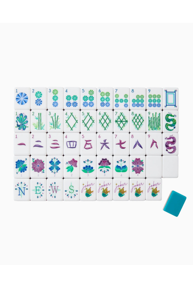 A set of Japanese mahjong tiles arranged in a grid on a white background, with a single blue tile placed to the lower right. The tiles feature various Japanese characters and patterns in blue, green, purple, and pink on a white base.