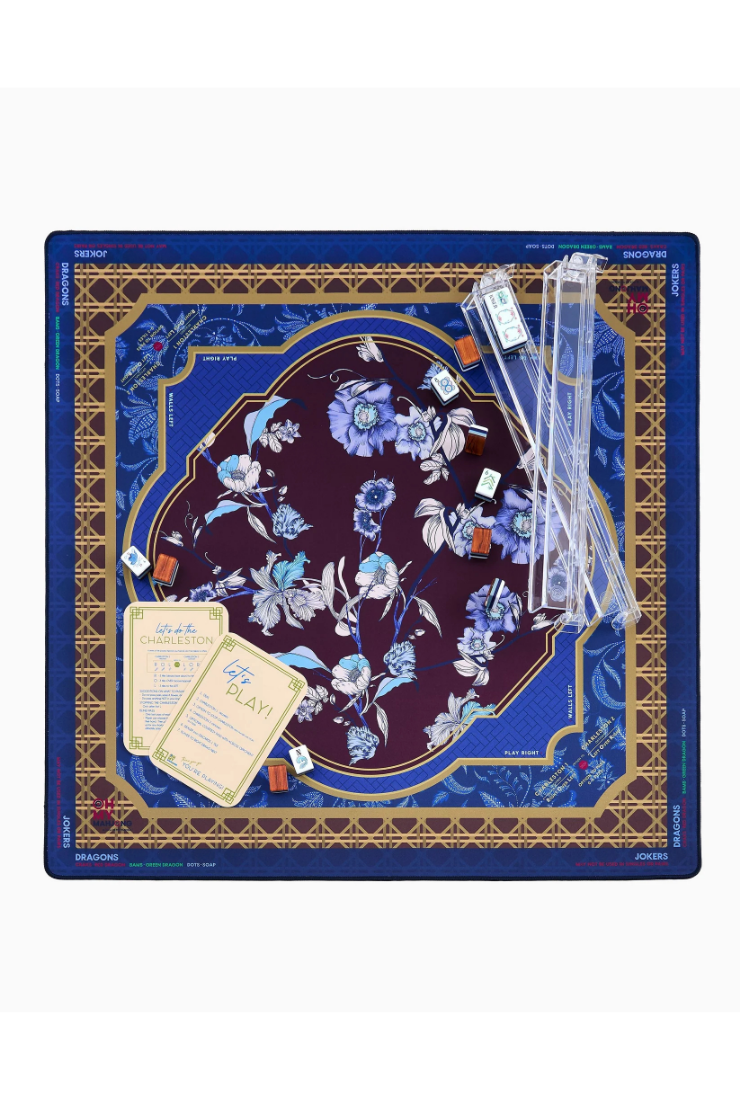 A square Jostein prayer rug set displayed flat against a white background, featuring a dark blue outer border, a central navy and burgundy floral medallion, gold geometric accents, clear plastic handles, and prayer cards.