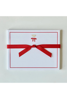 A white rectangular card or envelope with a thin red border, a small gold chalice icon near the top center, and a red ribbon tied around it, photographed on a light neutral background.