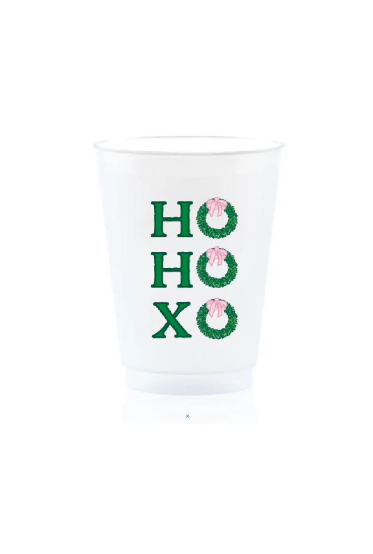 A white disposable plastic cup featuring a green and pink holiday graphic that reads 'HO HO XO' with wreath designs, shown on a plain white background.