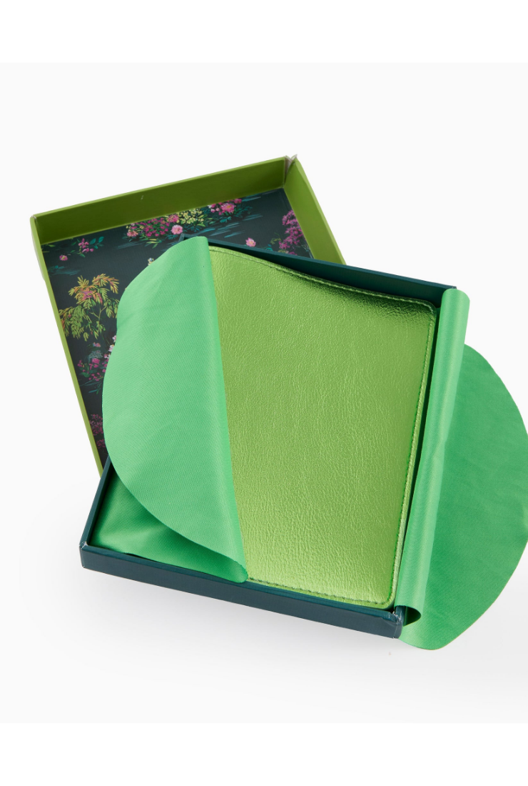Green leather wallet in an open box on a white background