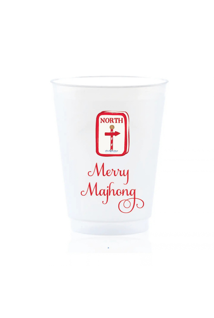 A clear plastic shot glass featuring a red graphic with a cross inside a border labeled 'NORTH' and the words 'Merry Majhong' in red script below, set against a plain white background.