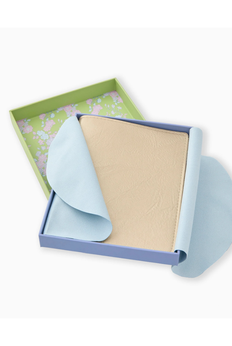 Folded fabric in a box with a floral pattern on a white background