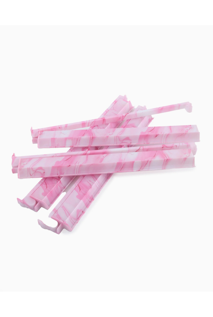 Pink and white striped straws on a white background
