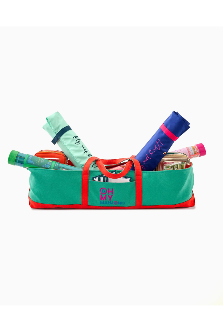 Green and red bag with stationery items on a white background
