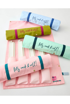 A pink fabric roll-up organizer with multiple compartments, shown partially unzipped with several rolled sleeves inside. The sleeves are in pastel blue, olive green, mint green, and light pink, each printed with the phrase 'let's rock & roll!' in script.