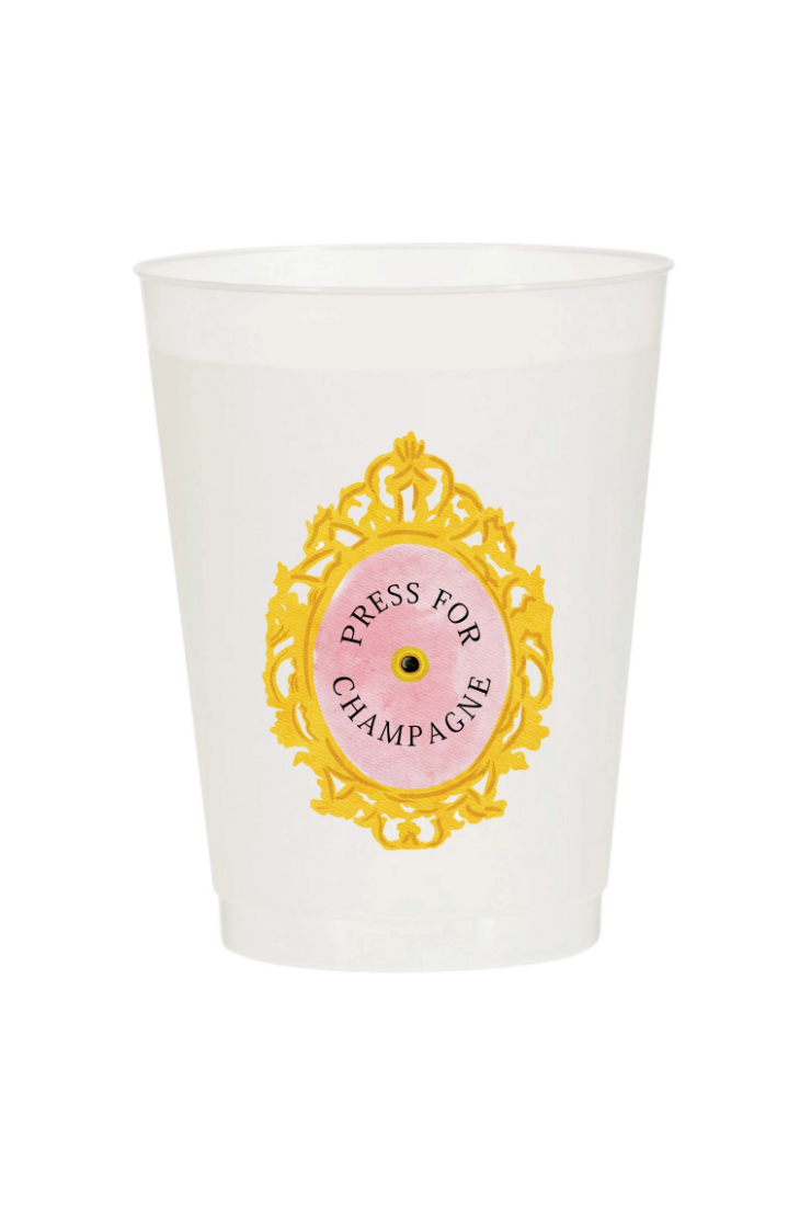 A translucent white plastic cup featuring a decorative gold baroque-style frame and a pink center medallion with the text 'PRESS FOR CHAMPAGNE'.