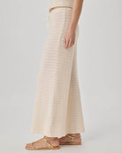 Person wearing a beige ribbed knit skirt on a plain background