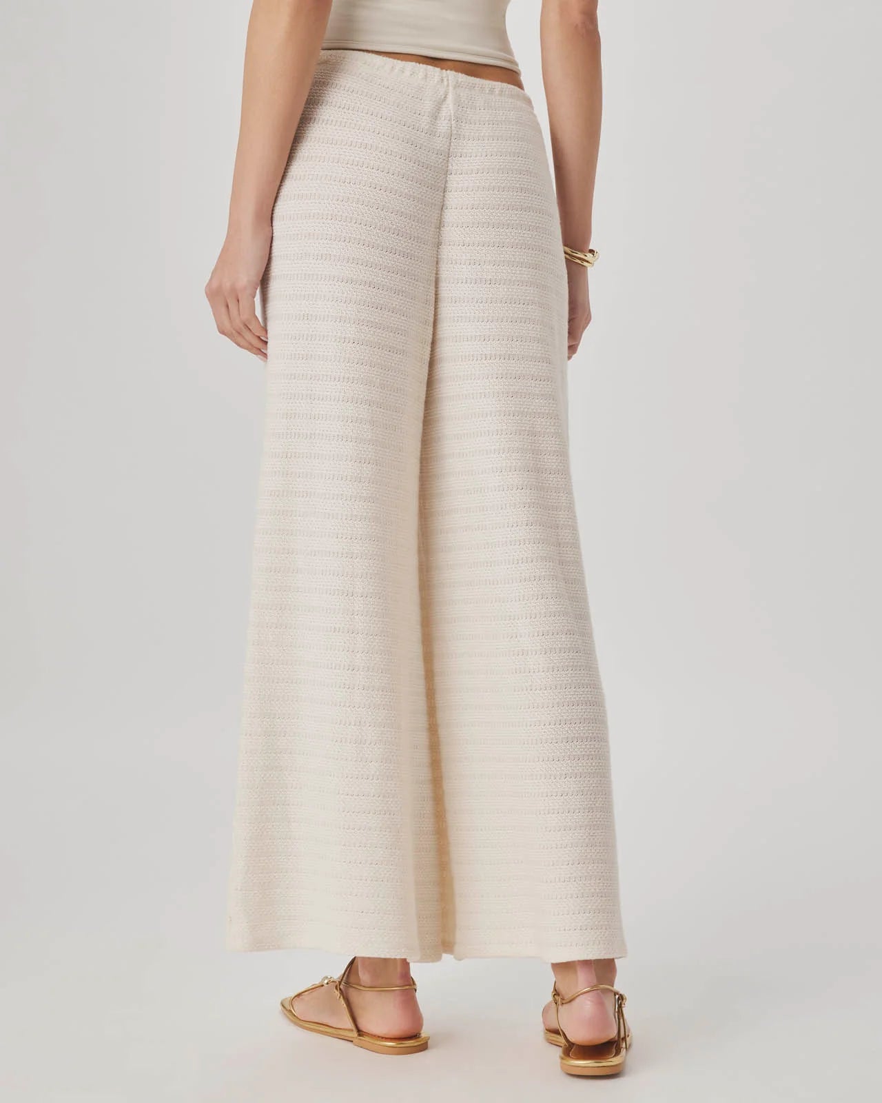 Person wearing a beige ribbed knit skirt on a plain background