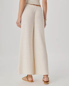 Person wearing a beige ribbed knit skirt on a plain background