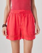 Red shorts worn by a person on a plain background