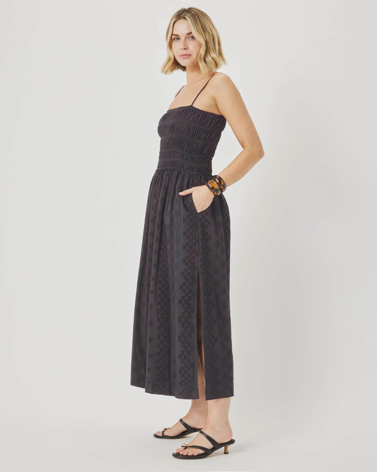 Woman wearing a black patterned dress on a white background