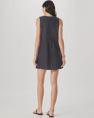 Woman wearing a dark gray sleeveless dress on a white background