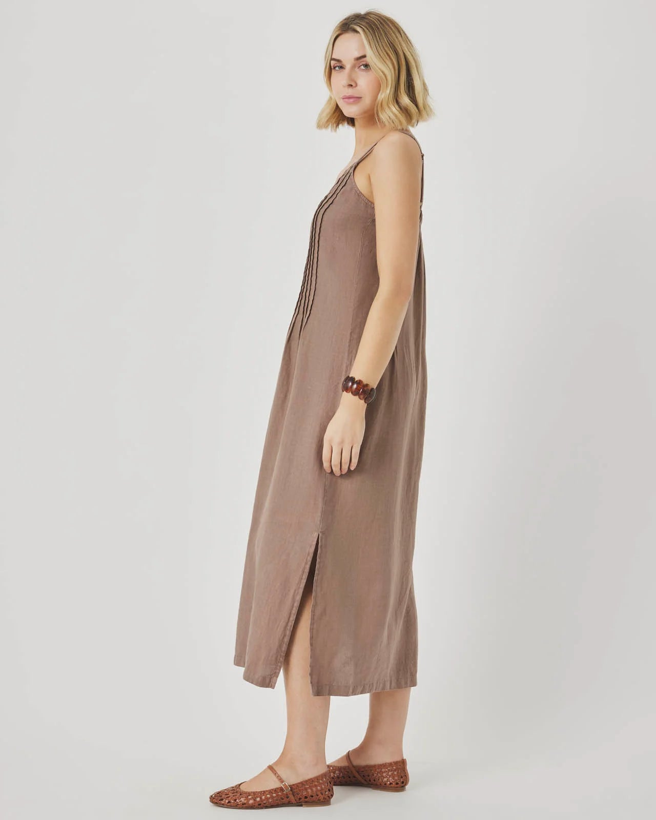 Woman wearing a brown slip dress on a white background