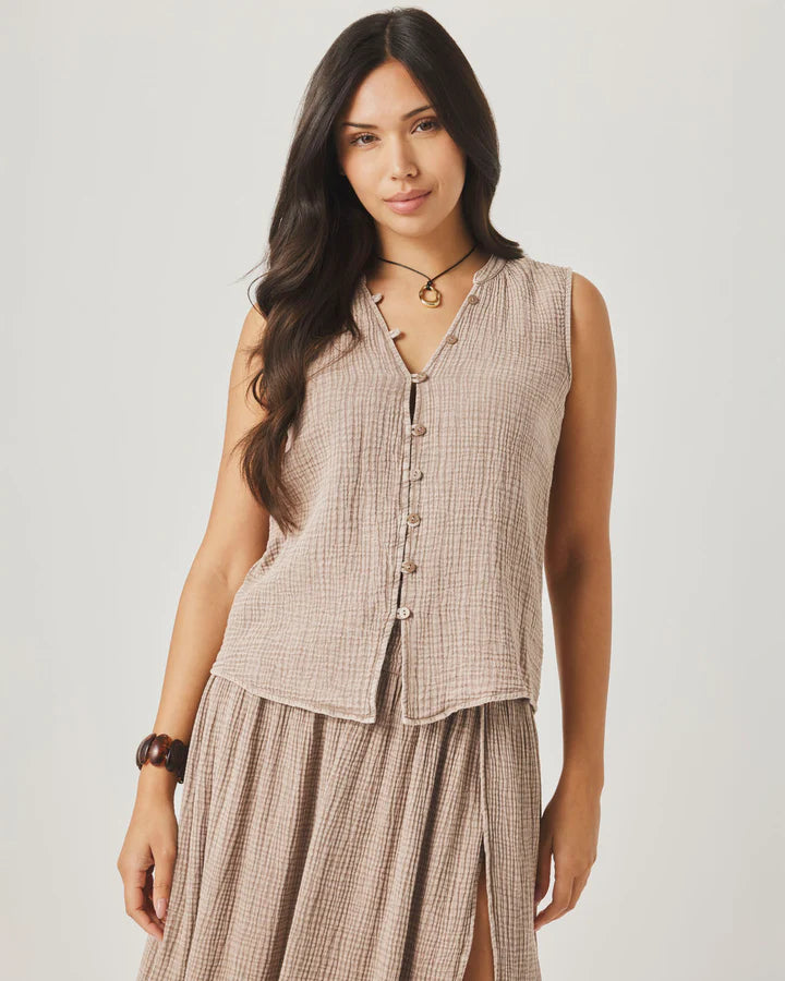 Woman wearing a sleeveless checkered top and skirt on a plain background