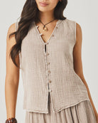 Woman wearing a sleeveless checkered top with a plain background