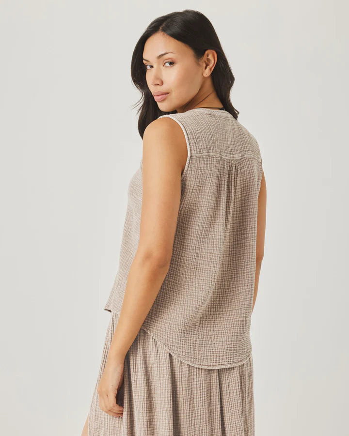 Woman wearing a sleeveless checkered top and skirt on a plain background
