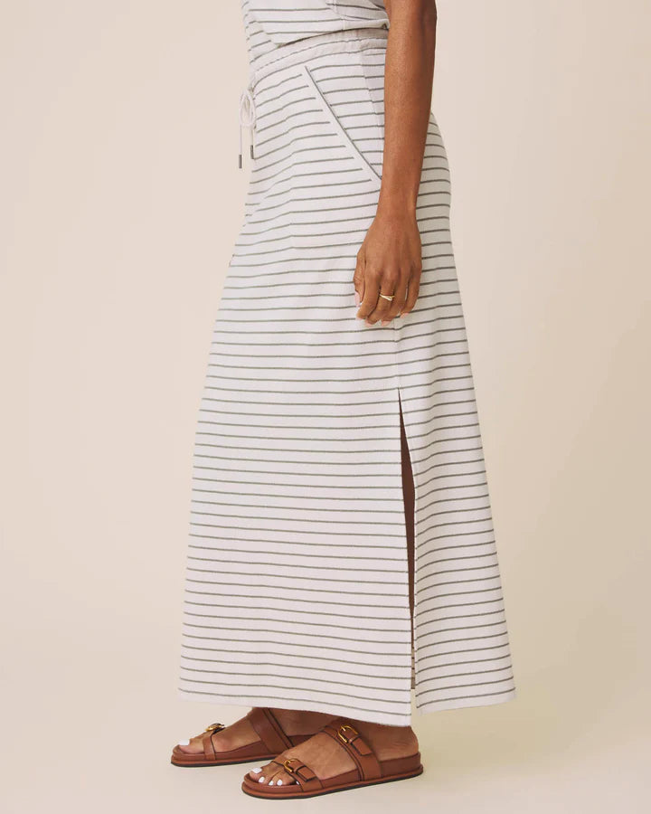 Person wearing a striped skirt with a plain background