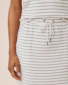 Person wearing a striped skirt with a plain background