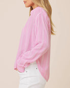 Pink sheer blouse worn by a person on a beige background