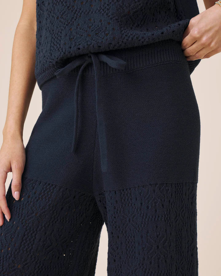 Navy blue textured top and pants set on a beige background