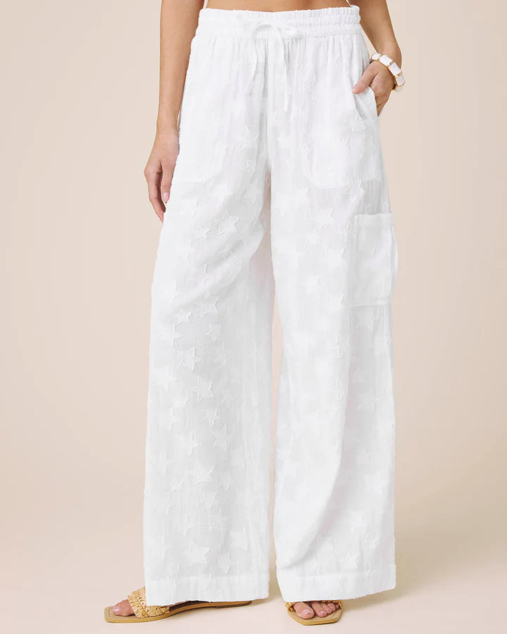 White wide-leg pants worn by a person on a beige background