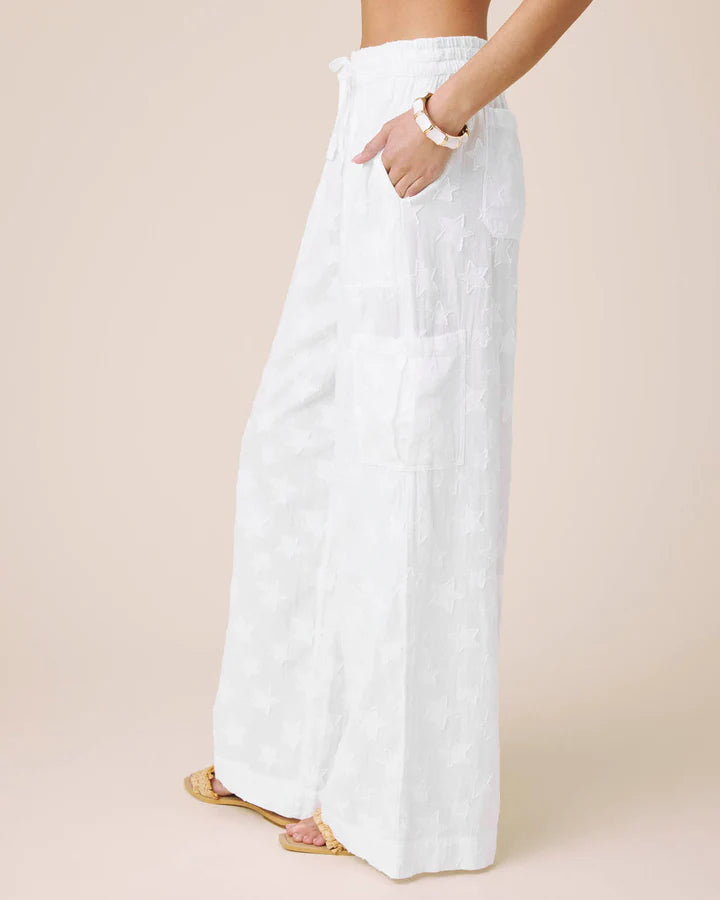 White wide-leg pants worn by a person on a beige background