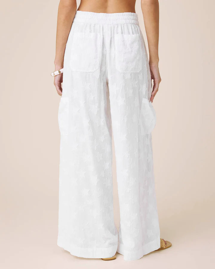 White wide-leg pants worn by a person on a beige background