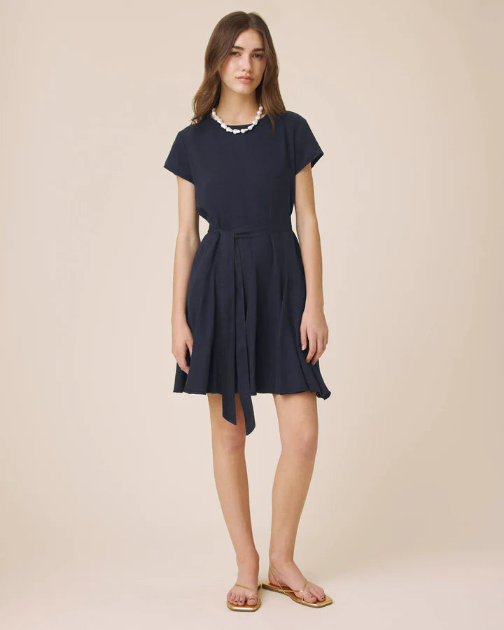 Woman wearing a navy blue dress on a beige background