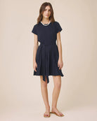 Woman wearing a navy blue dress on a beige background