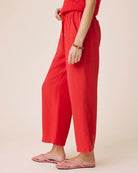 Person wearing red pants on a beige background