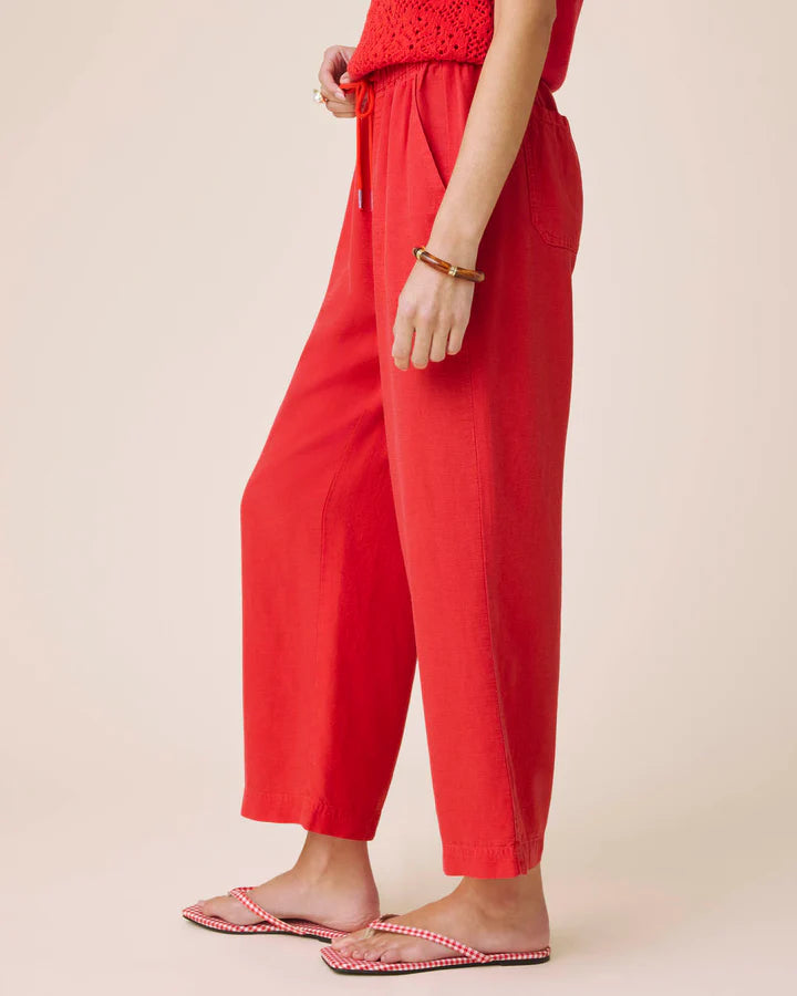 Person wearing red pants on a beige background