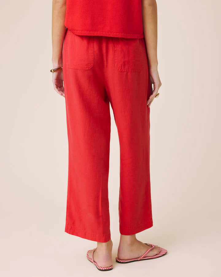 Person wearing red pants and a red top on a beige background
