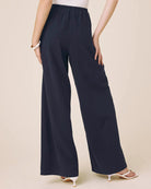 Person wearing navy wide-leg pants on a beige background