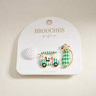Two decorative brooches on a 'Brooches by Influence' card against a beige background.
