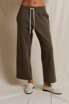 Brown pants with a white drawstring on a neutral background