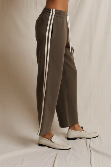 Brown pants with white stripes on a neutral background