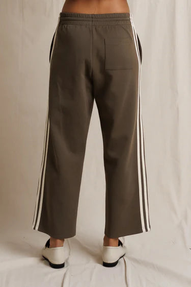 Brown pants with white stripes on a neutral background
