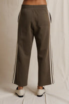 Brown pants with white stripes on a neutral background