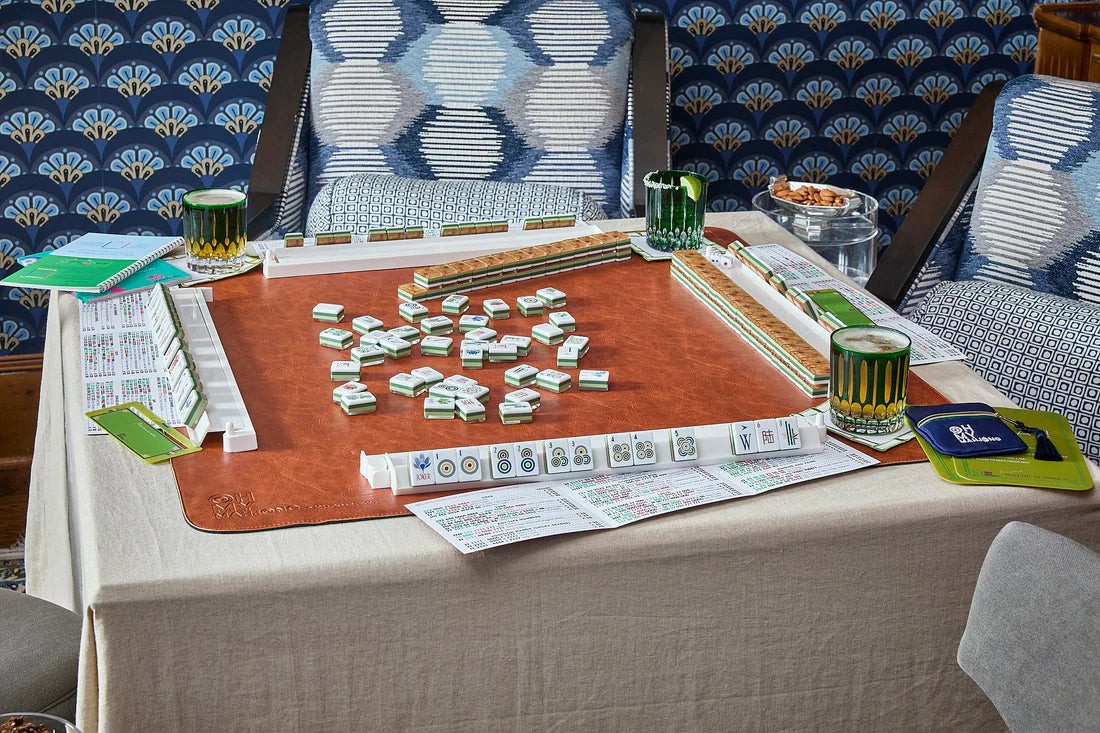 Mahjong game set up on a table with drinks and cards