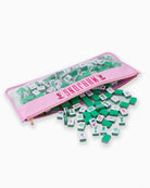 Green and white game pieces with pink carrying case on a white background