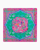 Colorful decorative mat with floral patterns and green border on a pink background