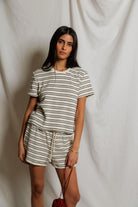 Woman wearing a striped outfit against a plain background