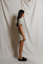 Person wearing a striped outfit standing against a plain white background