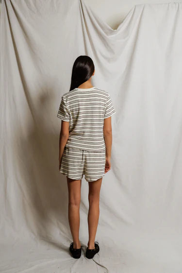 Person wearing a striped outfit standing against a plain white background