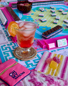 Colorful board game with a drink and snacks on a table