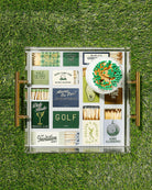 Collection of vintage golf-themed matchbooks in a glass case on grass