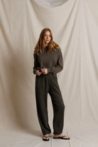 Person wearing a dark gray outfit against a plain background