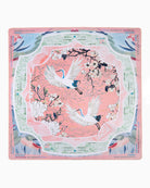 Decorative placemat with cranes and floral design on a pink background